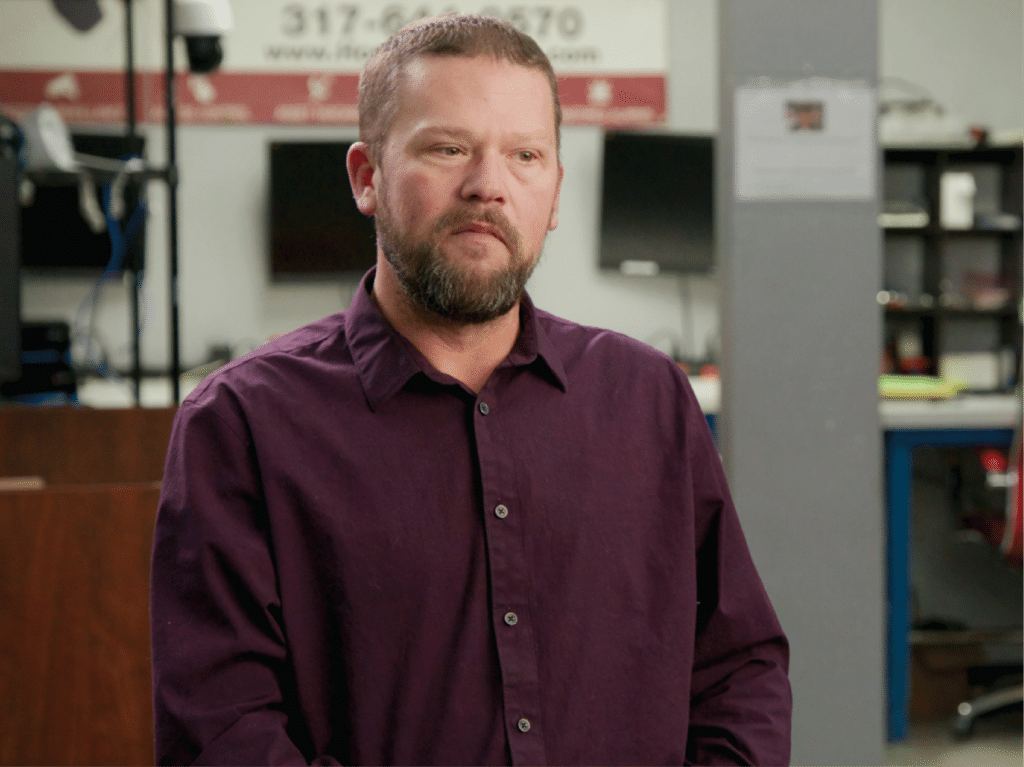 Director of Services Brian Halterman sits to talk about his lifechanging experience, wearing a deep purple shirt.