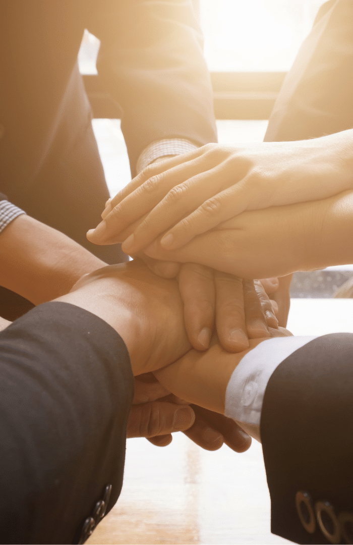 hands stacked on top of each other as a sign of teamwork in business consulting